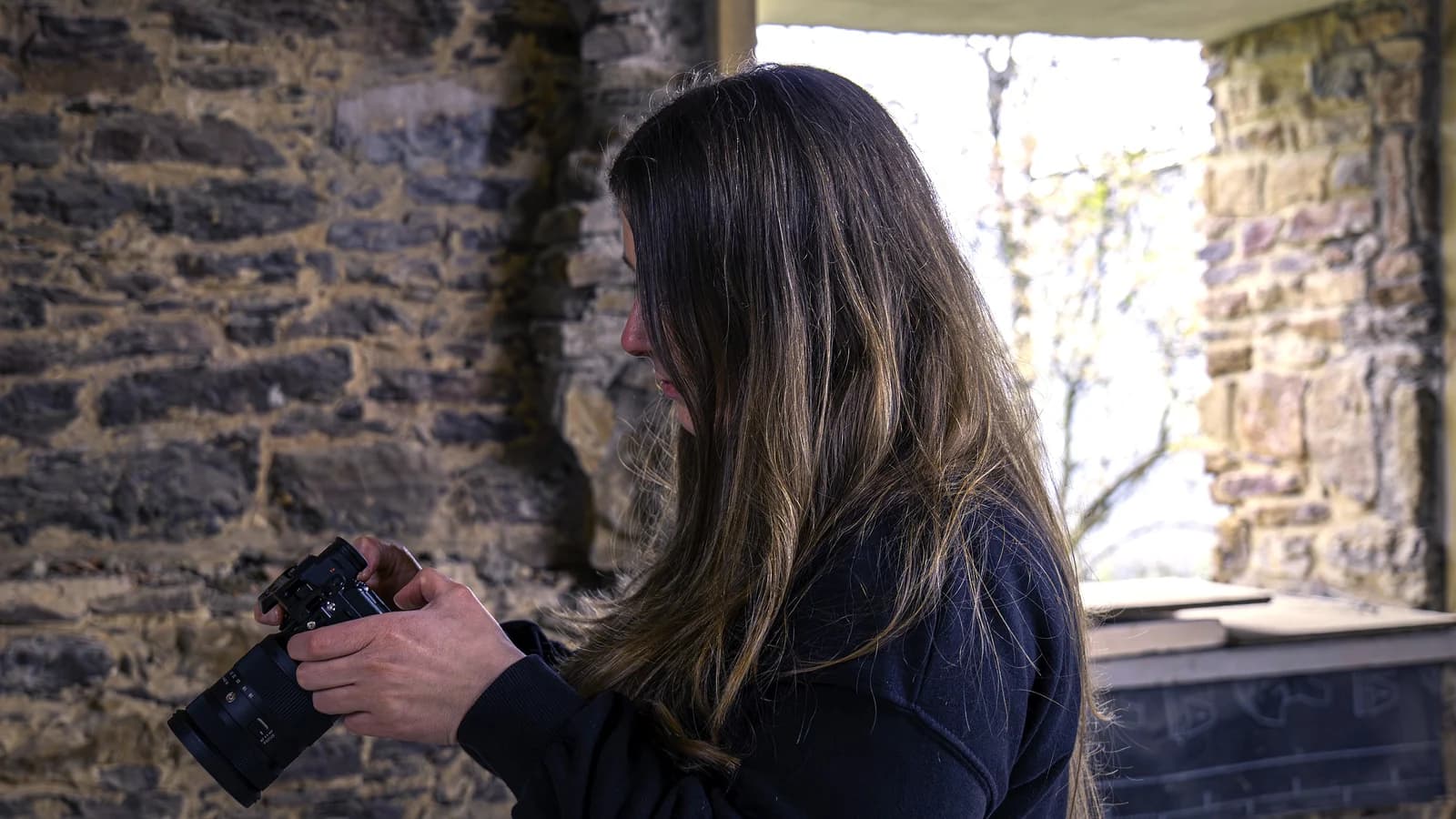 Videógrafa preparando la cámara para grabar contenido en una obra de rehabilitación